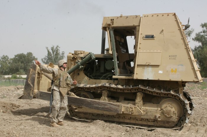 Sergeant Joshua Merriman, Beckley, W. Va. native and project manager directs one of the Marine's on his crew. The 10 Marines with Heavy Equipment Platoon, Support Company, 8th Engineer Support Battalion, 2d Force Service Support Group (Forward), built a new Entry Control Point on Camp Habbaniyah recently to enhance force protection on the base.