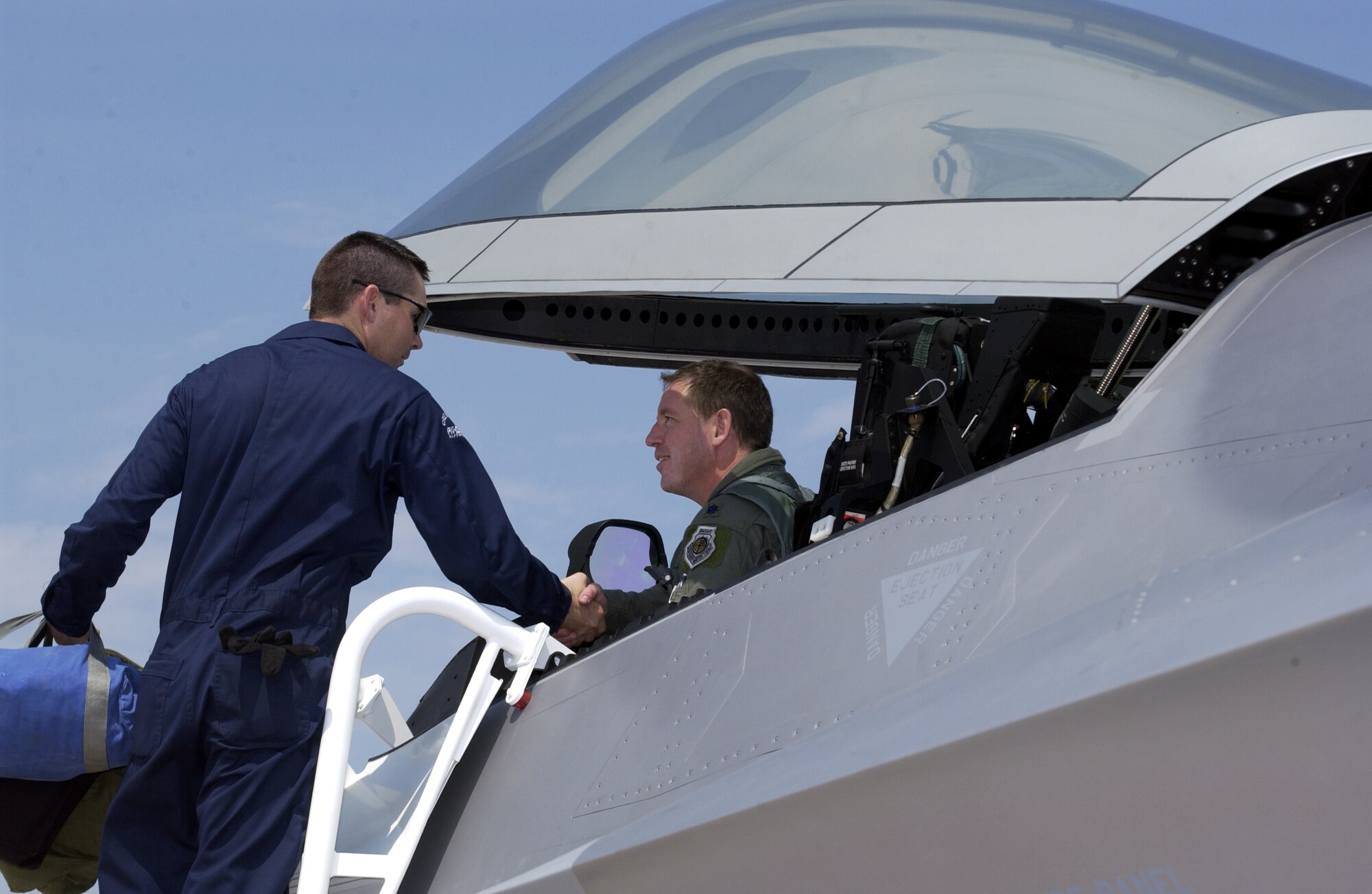 LANGLEY AIR FORCE BASE, Va. -- Staff Sgt. John Barr greets Lt. Col. James Hecker after delivering the first operational F/A-22 Raptor to its permanent home here May 12.  This is the first of 26 Raptors to be delivered to the 27th Fighter Squadron.  The Raptor program is managed by the F/A-22 System Program Office at Wright-Patterson Air Force Base, Ohio.  Colonel Hecker is the squadron's commander, and Sergeant Barr is an F/A-22 crew chief.  (U.S. Air Force photo by Staff Sgt. Elizabeth Weinberg)
