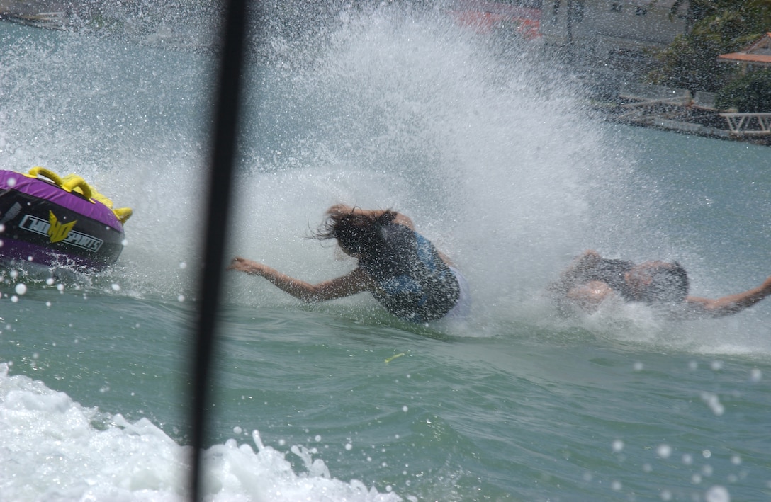 Lianne Manalo (right) and Clifford Doctolero fly off of the bumper tube after getting towed around a sharp turn.  Both riders had already experienced parasailing and jet skiing at Hawaii Water Sports in the Koko Marina Shopping Center in Hawaii Kai. Hawaii Water Sports offers Jet Skiing, wakeboarding, scuba, surfing and many other watersports.