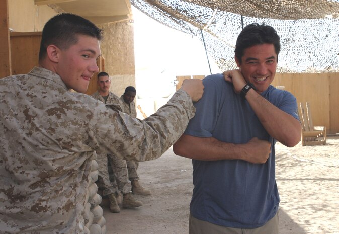 Corporal John E. Lawson Jr., Digital Video Imagery Distribution System manager, Headquarters and Service Battalion, 2d Force Service Support Group (Forward), throws a mock punch at Dean Cain, a Malibu, Calif., native, during the actor?s visit to Camp Taqaddum May 14 as part of the Ambassadors of Hollywood tour. ?I punched superman!? the Northfield, Ohio, native exclaimed as Cain laughed and continued to entertain U.S. service members deployed overseas. (Photo by Sgt. Kristin S. Jochums)