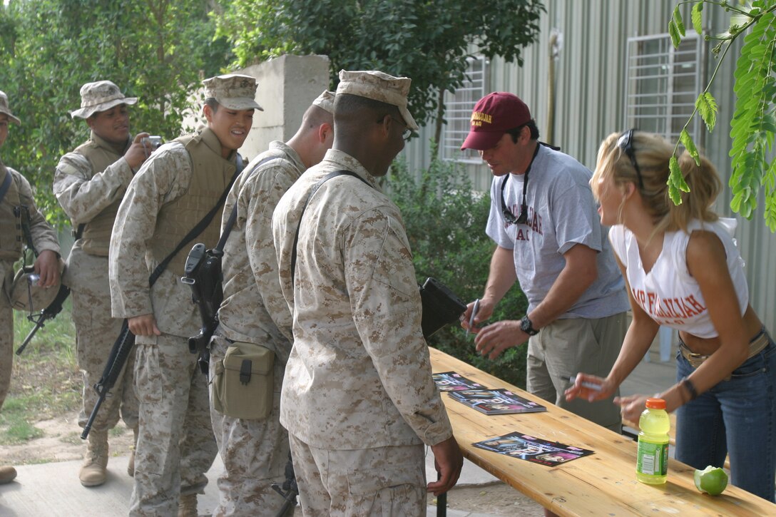 Dean Cain, actor and producer, and Amanda Swisten, model and actress, sign autographs for troops at the camp exchange on May 15.  The celebrities are making several stops in Iraq in the next few weeks.