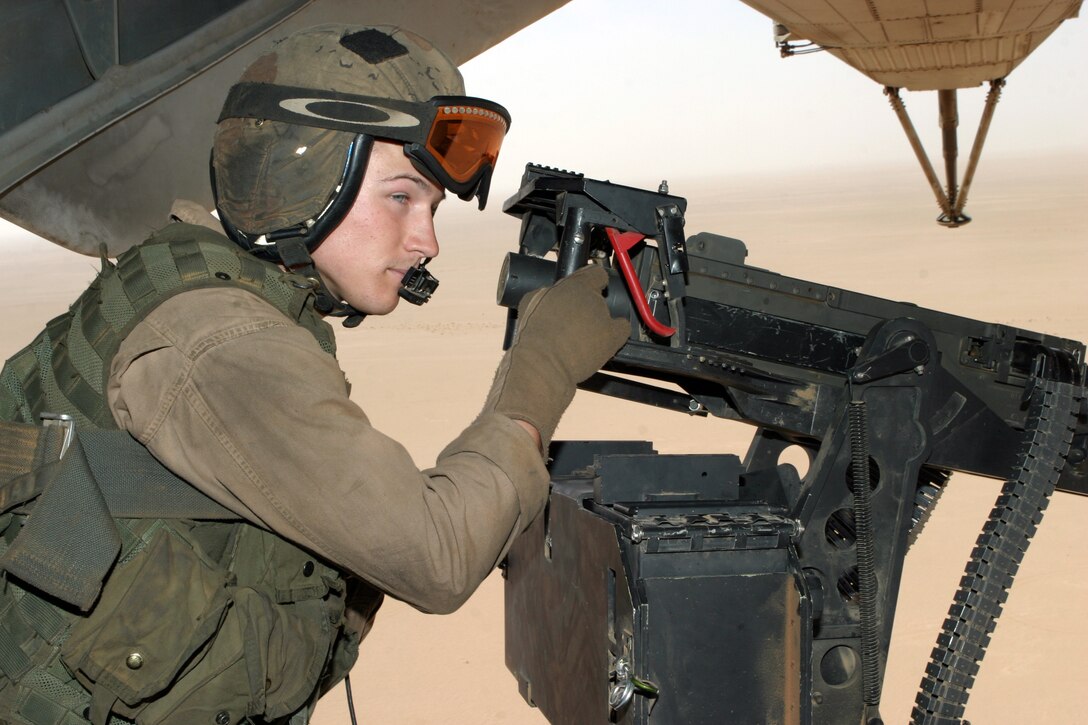 AL ASAD, Iraq - Sgt. Seth Thornton, a CH-53E Super Stallion crewchief assigned to Marine Heavy Helicopter Squadron 465, keeps a good look on the ground for enemy activity while flying over the Iraqi desert May 19.  Thornton, from Abilene, Texas, is in his third tour here in support of Operation Iraqi Freedom.