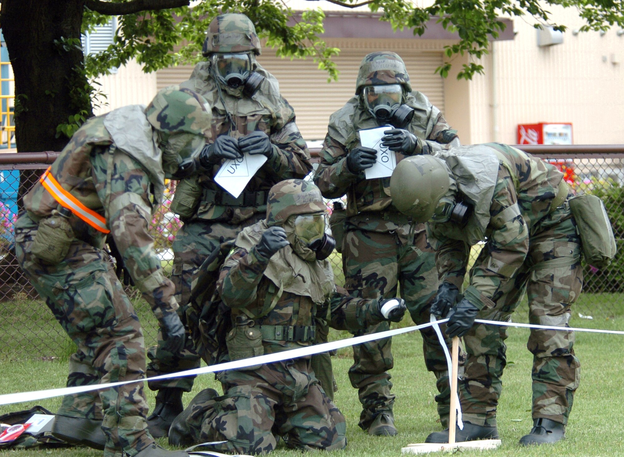 YOKOTA AIR BASE, Japan -- Airmen from the 374th Civil Engineer Squadron secure a "contaminated area" after an "attack" during "ability to survive and operate" training here.  About 100 civil engineers refamiliarized themselves with protective procedures, planning post-reconnaissance attack routes, Mark-1 antidote kits and contaminated control area procedures during training.  (U.S. Air Force photo by Master Sgt. Val Gempis)