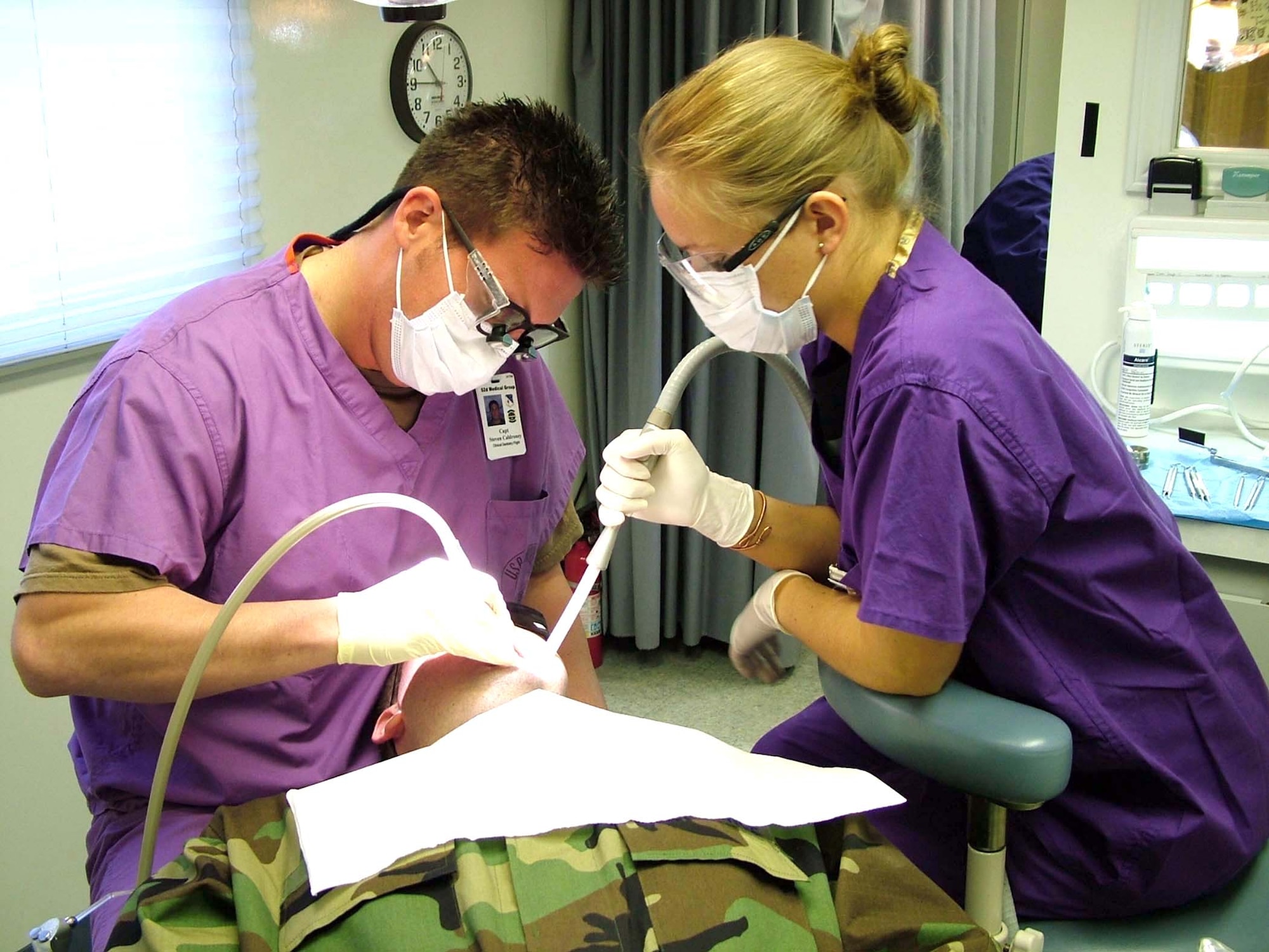 BUECHEL AIR BASE, Germany -- Staff Sgt. Joseph Toth gets a tooth filled by Capt. (Dr.) Steven Caldroney and Airman 1st Class Terah Murphy during their spring visit here May 12.  The 52nd Dental Squadron's dental bus from Spangdahlem Air Base visits four geographically separated unit sites in three countries twice a year.  Sergeant Toth is an emergency actions controller with the 702nd Munitions Support Squadron command post.  (U.S. Air Force photo by Airman 1st Class Eydie Sakura)