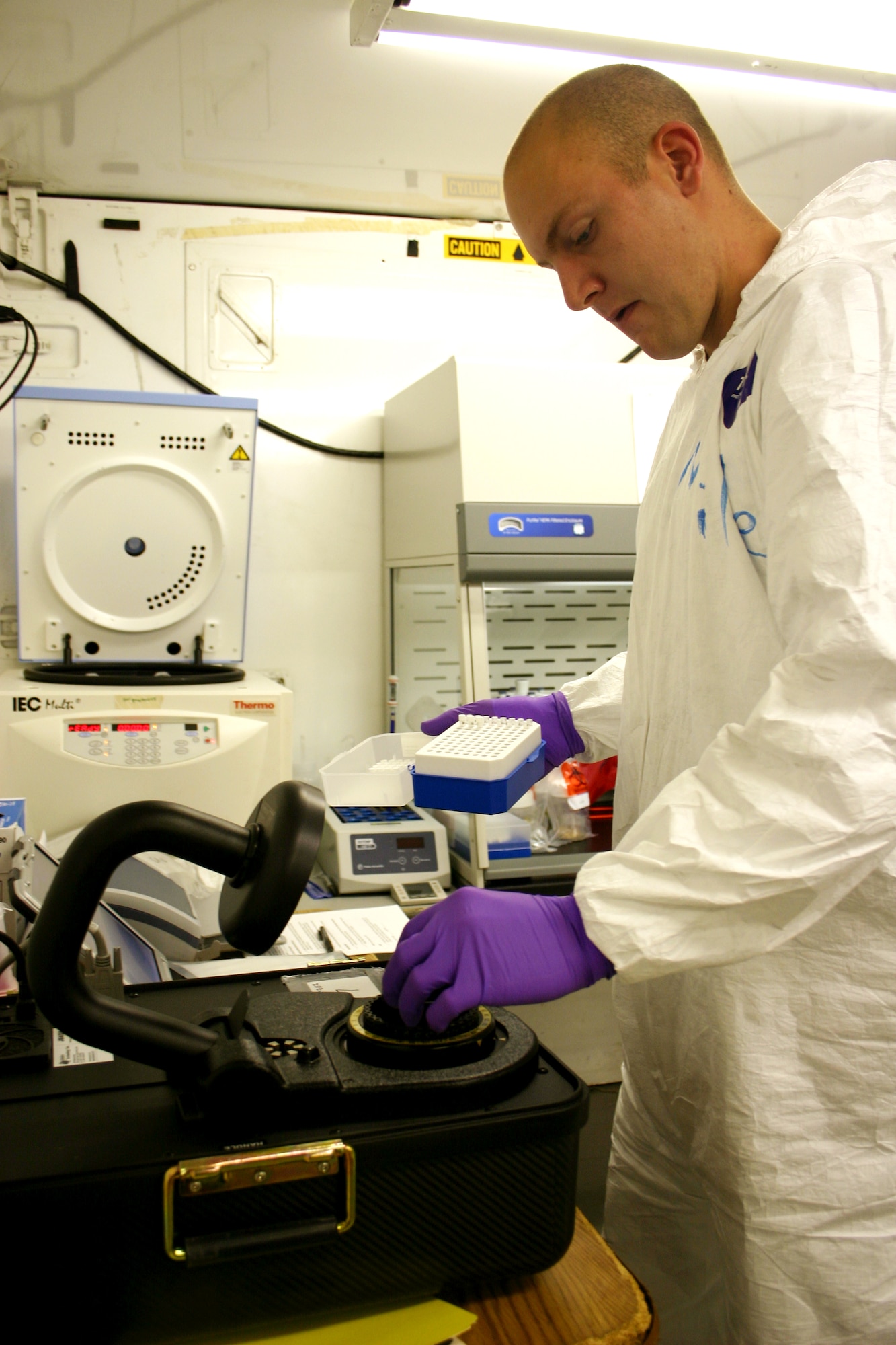 BROOKS CITY-BASE, Texas -- Army Spc. Paul Miller loads the joint biological agent identification and diagnostic system analyzer carousel with samples.  It takes the system about 40 minutes to process a sample once the extraction process of a suspect biological warfare agent specimen is complete.  Specialist Miller is from the 9th Area Medical Laboratory at Aberdeen Proving Ground, Md.  (U.S. Army photo by Elaine Wilson)