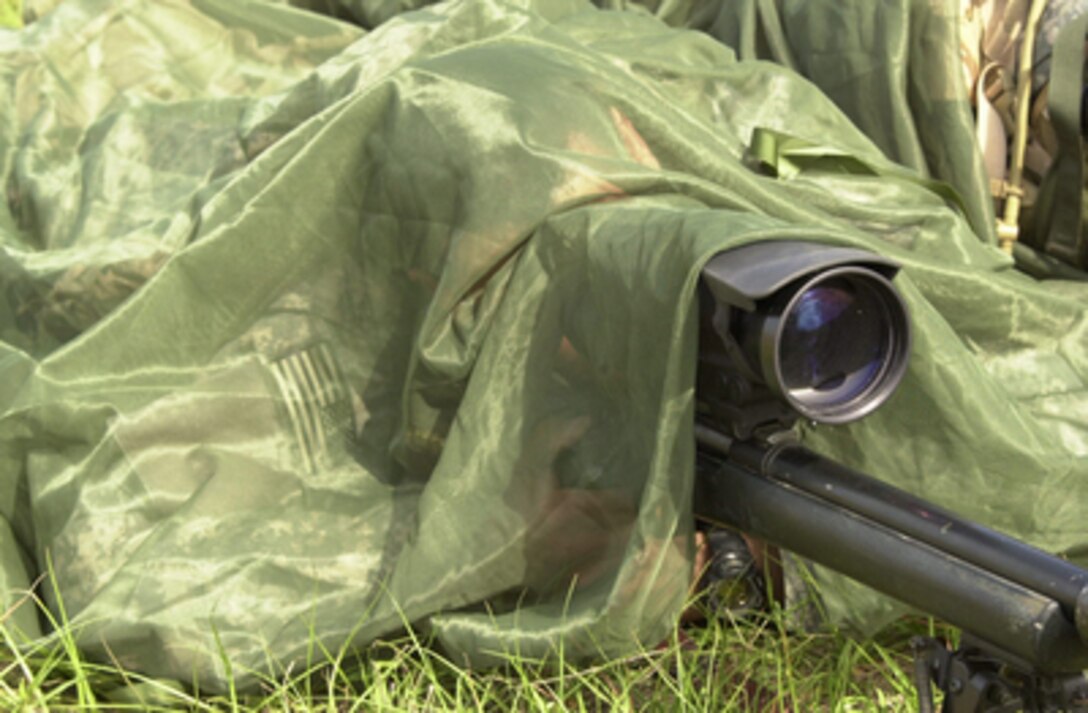 Pfc. Anthony DeLaReal conceals his body and part of his M-24 sniper rifle during a training exercise at the Joint Readiness Training Center at Fort Polk, La., on May 16, 2005. DeLaReal is assigned to Headquarters Company, 2nd Battalion, 1st Infantry Division that is training for deployment in support of Operation Iraqi Freedom. 