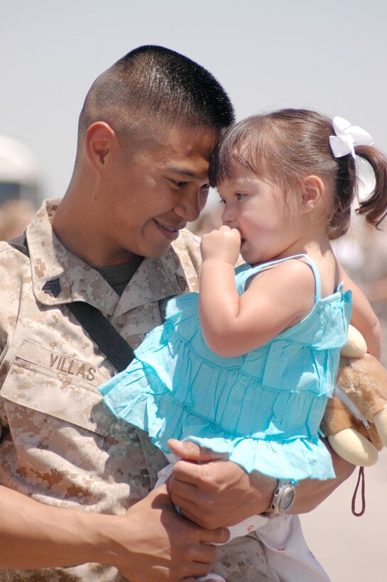 Sgt. Fred Villas, Marine Aviation Logistics Squadron-13 hydraulics mechanic, holds his daughter Emilie Villas, 2, May 19 at Marine Attack Squadron-311's hangar after a six-month deployment to Iraq.