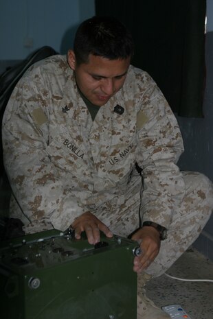 CAMP TAQADDUM, Iraq (May 23, 2005) -  Petty Officer 2nd Class Luis Bonilla, a dental equipment repair technician with Headquarters and Service Battalion, 2d Force Service Support Group (Forward), prepares a Dental Equipment Field Treatment Operating System during a humanitarian assistance mission in Habbaniyah May 20. The Miami native was part of a three-man team treating Iraqi Intervention Force soldiers who complained of pain and needed teeth surgically removed. (Photo by Cpl. John E. Lawson Jr.)