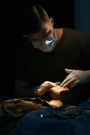 CAMP TAQADDUM, Iraq (May 23, 2005) -  Commander William Davidson, doctor of dental surgery and dental platoon commander with Headquarters and Service Battalion, 2d Force Service Support Group (Forward) inspects the teeth of an Iraqi Intervention Force soldier before performing oral surgery during a humanitarian assistance mission in Habbaniyah May 20. The Littlefield, Texas, native led a three-man team during the mission, treating 33 patients and removing 63 teeth, mostly half-decayed, from soldiers who had previously complained of pain. (Photo by Cpl. John E. Lawson Jr.)