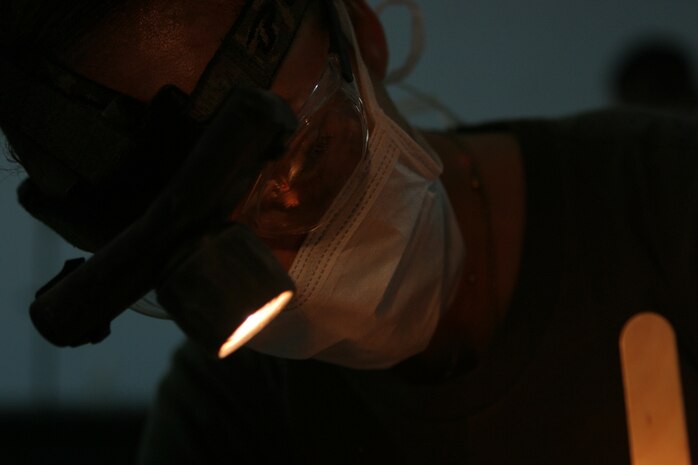 CAMP TAQADDUM, Iraq (May 23, 2005) -  Petty Officer 3rd Class Iris Manso, a dental technician with Headquarters and Service Battalion, 2d Force Service Support Group (Forward) prepares an Iraqi Intervention Force soldier for oral surgery during a humanitarian assistance mission in Habbaniyah May 20. The Kissimmee, Fla., and two other Sailors treated 33 patients who complained of pain during the two-day mission. (Photo by Cpl. John E. Lawson Jr.)