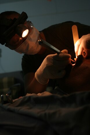 CAMP TAQADDUM, Iraq (May 23, 2005) -  Petty Officer 3rd Class Iris Manso, a dental technician with Headquarters and Service Battalion, 2d Force Service Support Group (Forward) prepares an Iraqi Intervention Force soldier for oral surgery during a humanitarian assistance mission in Habbaniyah May 20. The Kissimmee, Fla., and two other Sailors treated 33 patients who complained of pain during the two-day mission. (Photo by Cpl. John E. Lawson Jr.)