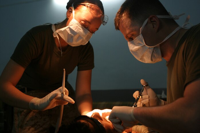 CAMP TAQADDUM, Iraq (May 23, 2005) -  Commander William Davidson, doctor of dental surgery and dental platoon commander with Headquarters and Service Battalion, 2d Force Service Support Group (Forward) performs dental surgery on an Iraqi Intervention Force soldier during a humanitarian assistance mission in Habbaniyah May 20. The Littlefield, Texas, native, along with a two other Sailors, treated 33 patients and removed 63 teeth, mostly half-decayed, from soldiers who had previously complained of pain during this two-day mission. (Photo by Cpl. John E. Lawson Jr.)