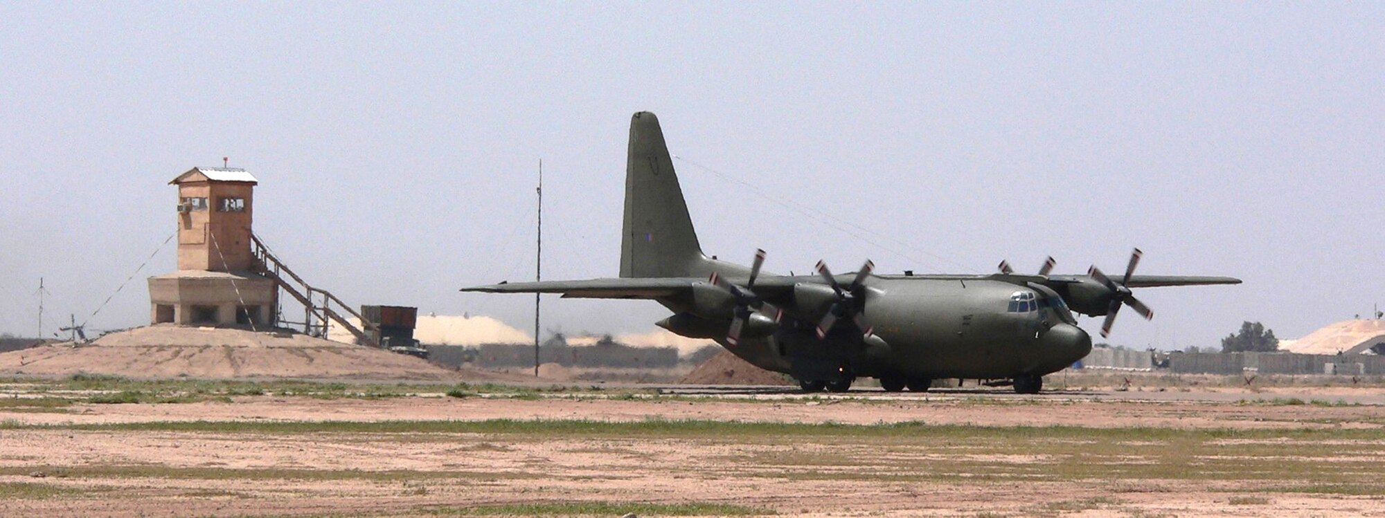 BALAD AIR BASE, Iraq -- A C-130 Hercules passes by the temporary air control tower nicknamed the "tree house," as it taxis down the runway. The tower was set up here to sustain flying missions while crews renovate the existing tower.  (U.S. Air Force photo by Staff Sgt. Joshua Hower)