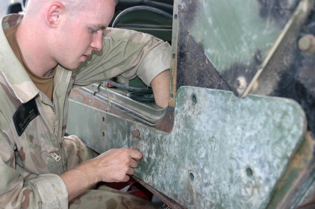 Cpl. Andrew T. Cain, a motor transport mechanic with Maintenance Platoon, MEU Service Support Group 26, 26th Marine Expeditionary Unit (Special Operations Capable), installs an armor panel on a humvee at Camp Buehring, Kuwait. The 26th MEU (SOC), currently deployed as the theater reserve for U.S. Central Command, is conducting training at the Udairi Range here through the end of the month. (Official USMC photo by Capt. Will Klumpp)
