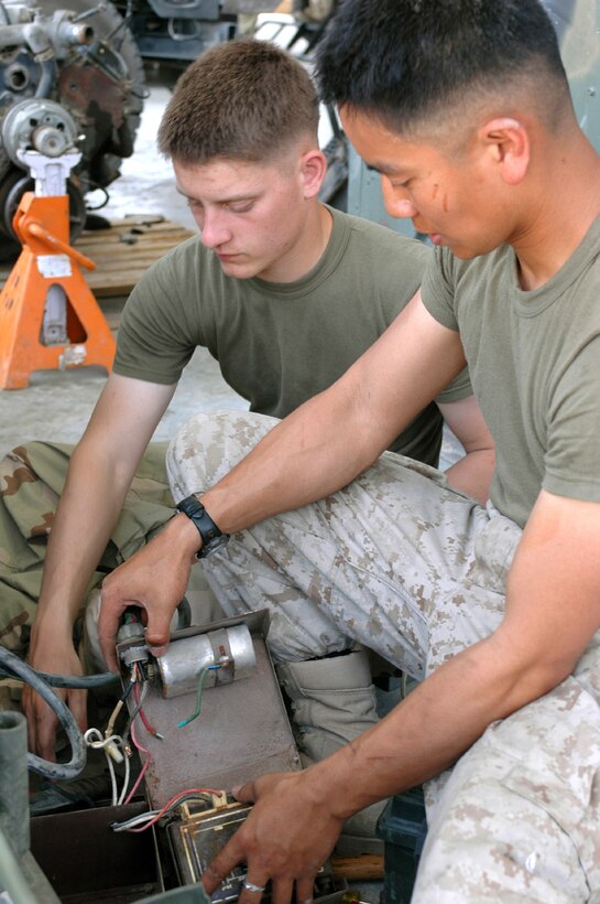 Cpl. Mansoo M. Masga, right, a generator mechanic, and Lance Cpl. Allen C. Meneh, a heavy equipment mechanic, repair a flood light at Camp Buehring, Kuwait. The MEU Service Support 26 Marines and the 26th MEU (SOC), currently deployed as the theater reserve for U.S. Central Command, are conducting training at the Udairi Range here through the end of the month. (Official USMC photo by Capt. Will Klumpp)