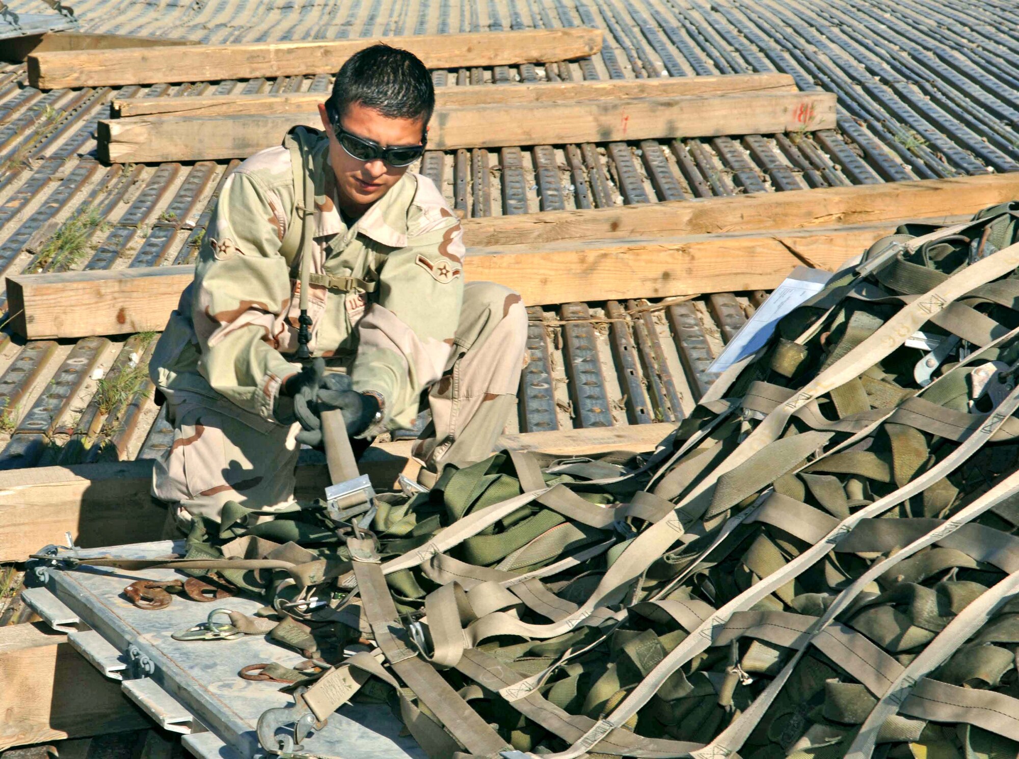 BAGRAM AIR BASE, Afghanistan -- Airman Carlos Reyes secures nets for pallets after they were recovered by Airmen from the 455th Expeditionary Logistics Readiness Squadron.  The Airmen collected and returned 2,417 pallets and 4,489 net sets in three months.  (U.S. Air Force photo by Capt. Mark D. Gibson)
