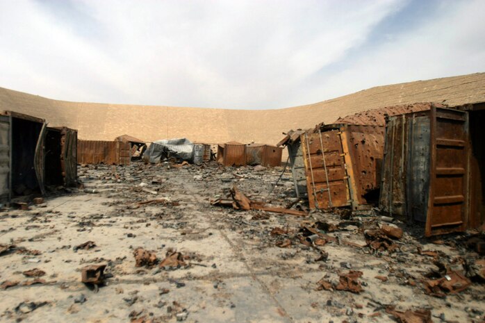 CAMP TAQADDUM, Iraq -- Unexploded ordnance from a bunker in the Ammunition Supply Point lay scattered after insurgents landed a rocket within the confines of the ASP last year.  ::n::“It was pretty amazing because two containers of ammunition are still unaccounted for,” Staff Sgt. Shaun Adams, staff noncommissioned officer in charge of the Ammunition Supply Point. “They literally melted to the ground because everything was so hot. Parts of another ISO container ended up on the other side of the berm. [Explosive Ordnance Disposal] teams come out here regularly to help clean this place up.”