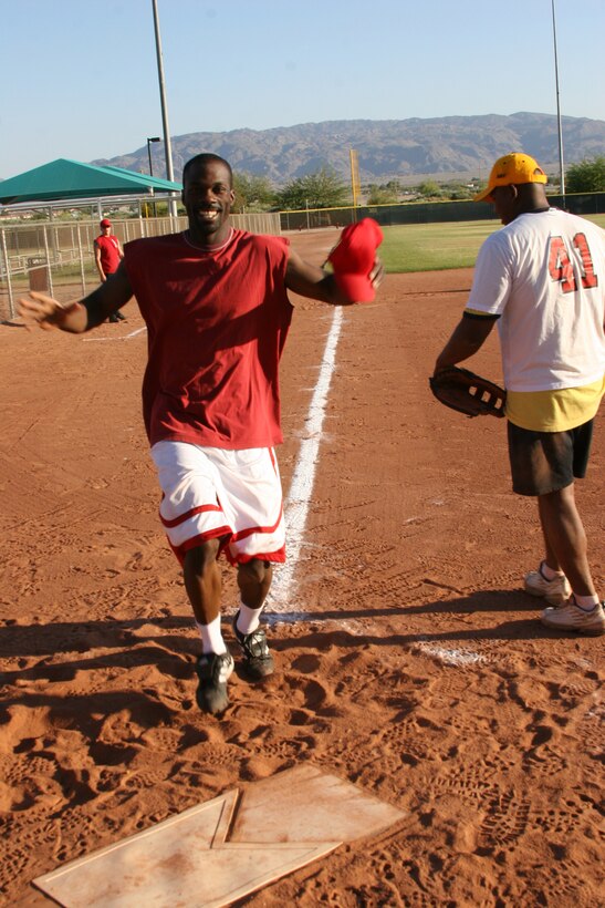 Antonio R. Griffin, catcher for Exercise Support Division, smiles while crossing home plate after hitting an in-the-park homerun during ESD?s softball double-header May 25 in game one against 3rd Battalion, 7th Marine Regiment at Felix Field. ESD defeated 3/7 13-8, and would later lose in game two against Marine Wing Support Squadron-374, 15-5.