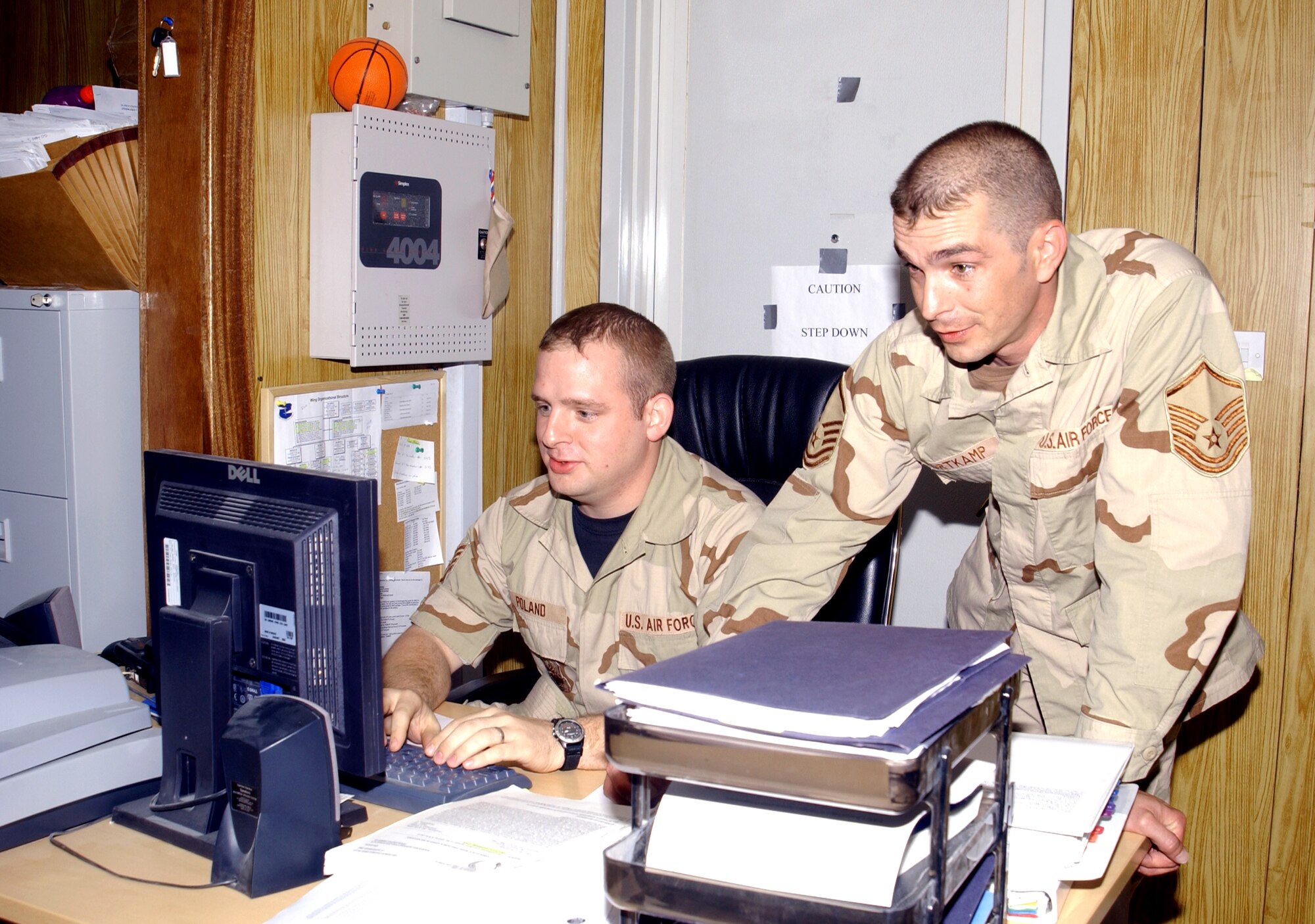 SOUTHWEST ASIA -- Staff Sgt. Ben Poland (left) and Master Sgt. Jack Kortkamp review personnel data at a forward-deployed location.  The six Airmen at the personnel office at this location accounted for more than 2,500 Airmen who were either outprocessing or inprocessing.  Sergeant Poland is a guardsman deployed from Bangor, Maine, and Sergeant Kortkamp is deployed from McConnell Air Force Base, Kan.  (U.S. Air Force photo by Master Sgt. Cheryl L. Toner)