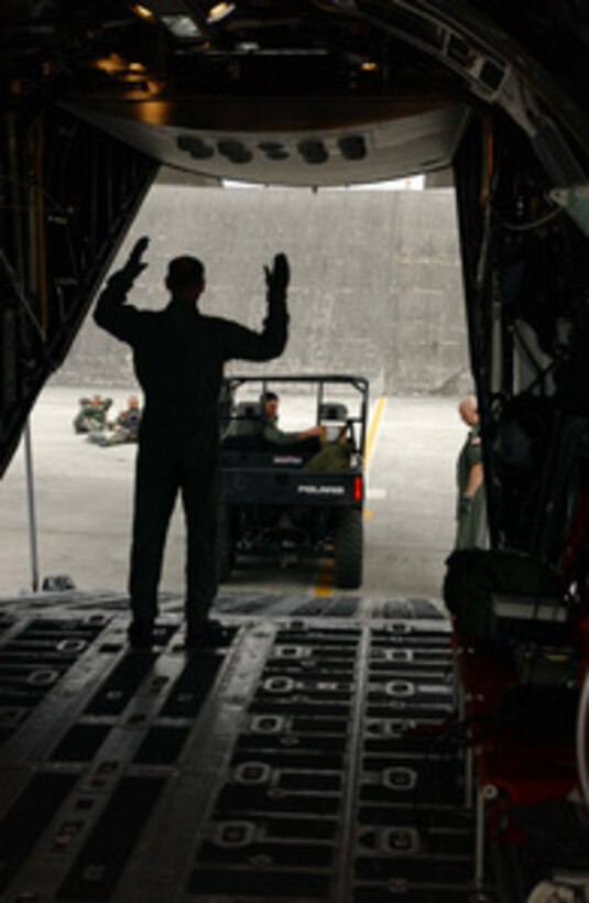 Master Sgt. Anthony Nawrocki guides the driver of an all terrain vehicle into the belly of an Air Force MC-130P Combat Shadow aircraft at Kadena Air Base, Japan, on May 23, 2005. The Combat Shadow is flying drop missions over Ie Shima Island as part of the Jackal Rally 2005 squadron aircrew competition. The week long competition tests the overall readiness capabilities of multiple aircrews to deploy members of a Special Tactics Squadron, and equipment Container Delivery Systems and Simulated Air Training Bundles over selected targets. Nawrocki is a navigator with the 17th Special Operations Squadron. 