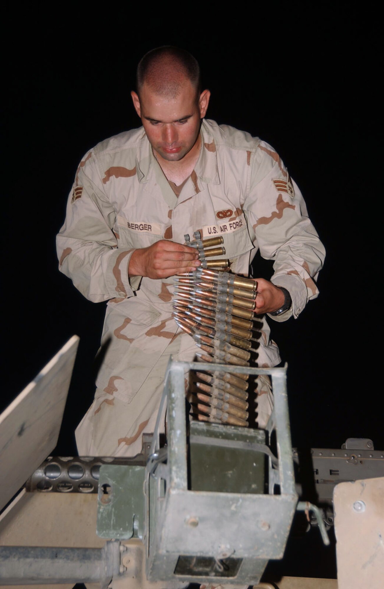 BALAD AIR BASE, Iraq -- Senior Airman Clint Berger loads ammunition before going out on a convoy.  His unit provides convoy protection to civilian contractors and Army units delivering supplies throughout the area of responsibility.  He is a gun truck operator with the 732nd Expeditionary Mission Support Group's Detachment 2632.  (U.S. Air Force photo by Staff Sgt. Lindsey Maurice)                