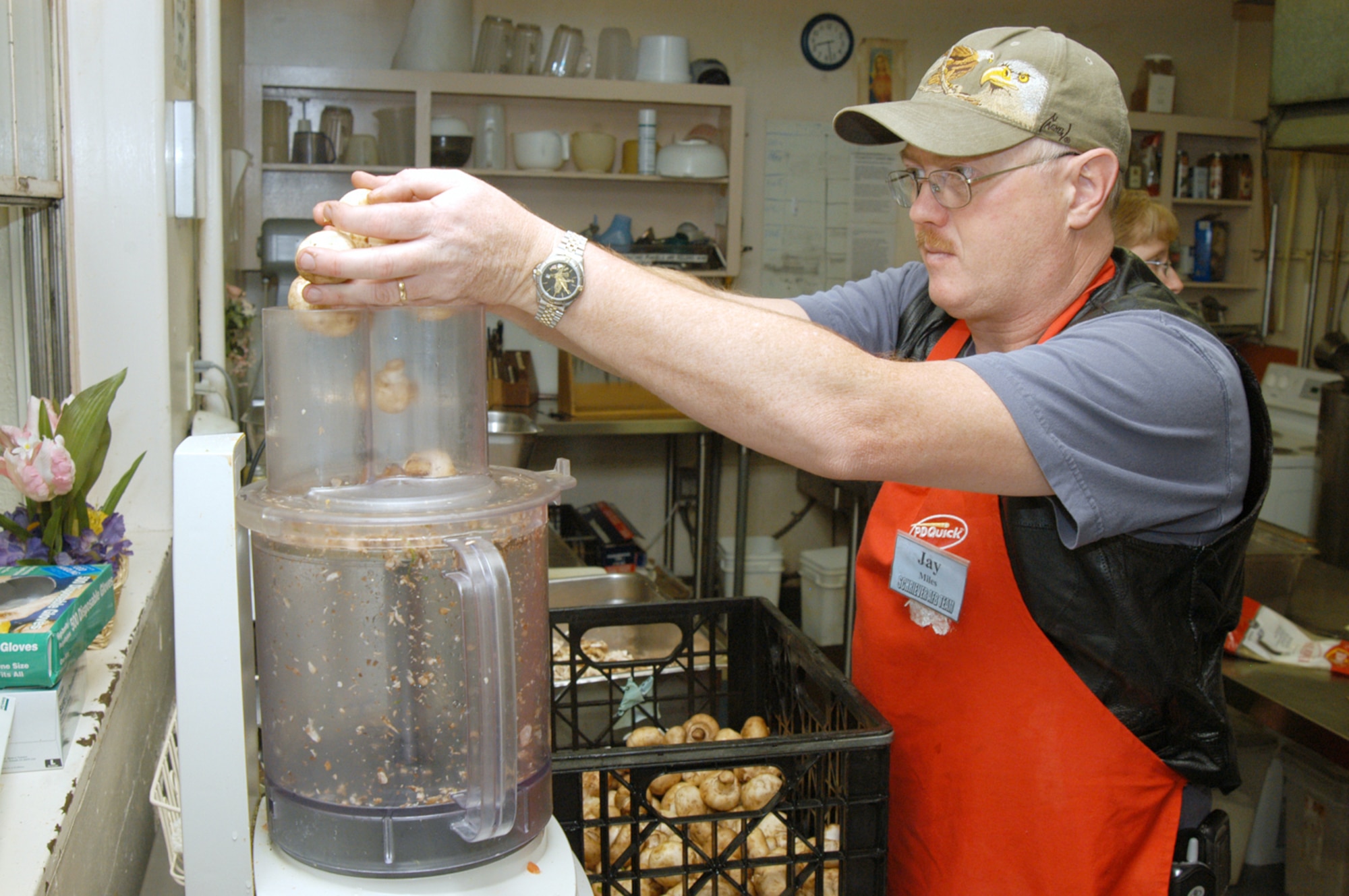 COLORADO SPRINGS, Colo. -- Master Sgt. Jay Miles dumps mushrooms into an automatic dicer at Marian House.  The house provides food and other aid to people who cannot afford a warm meal.  Sergeant Miles is assigned to the 50th Comptroller Squadron at nearby Schriever Air Force Base.  (U.S. Air Force photo by Staff Sgt. Don Branum)