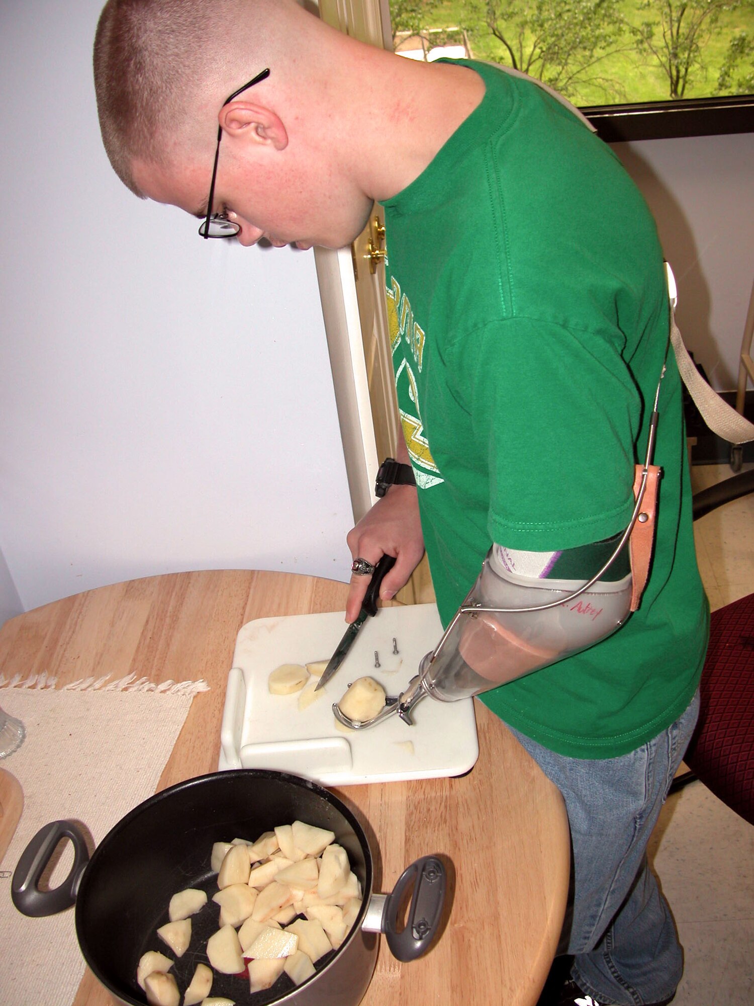 WASHINGTON -- Marine Lance Cpl. Ryan Autery, 20, uses his prosthetic left hand to hold a potato while cutting it with his right hand during cooking classes for troops with disabilities at Walter Reed Army Medical Center.  (Department of Defense photo by Rudi Williams)