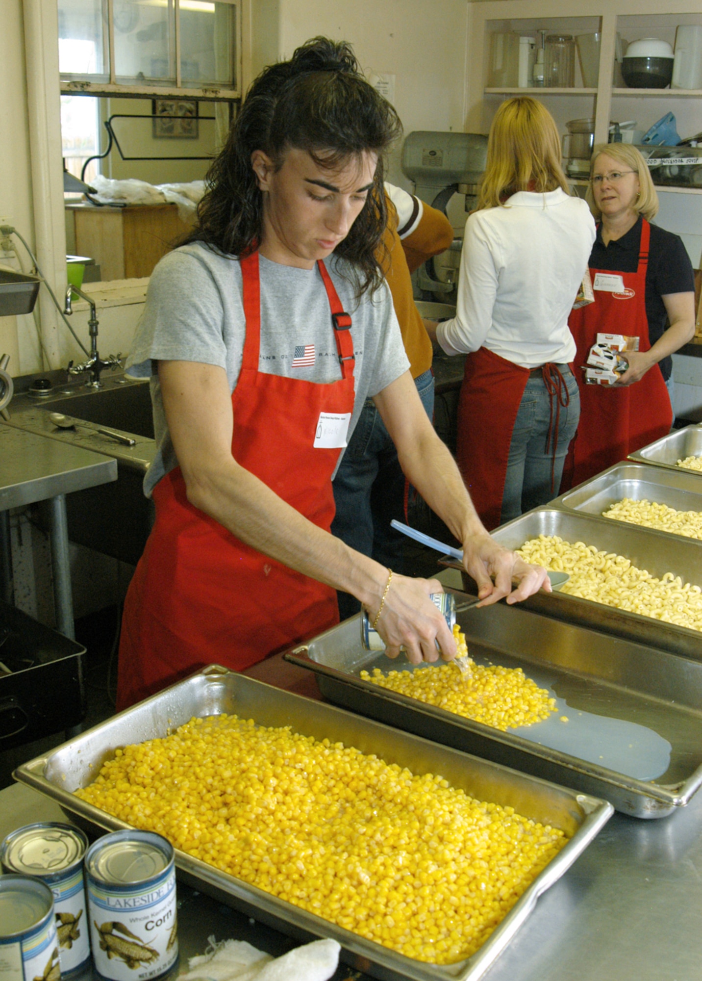 COLORADO SPRINGS, Colo. -- Tech. Sgt. Nicola Natale pours corn into cooking pans to serve at lunch at Marian House.  The house provides food and other aid to people who cannot afford a warm meal.  Sergeant Natale is assigned to the 50th Contracting Squadron at nearby Schriever Air Force Base.  (U.S. Air Force photo by Staff Sgt. Don Branum)
