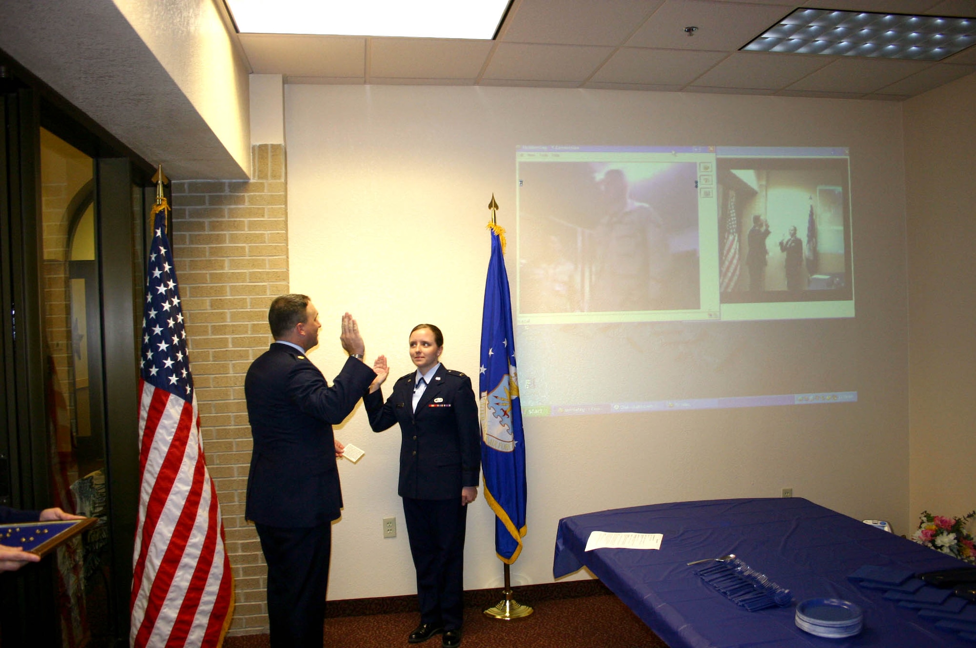 LAUGHLIN AIR FORCE BASE, Texas -- Maj. Gary Barlet administers the oath of office to 1st Lts. Eric and Sheila Johnston during their promotion ceremony via video conference May 26.  She is assigned to the 47th Flying Training Wing's public affairs office here, and her husband is deployed to Balad Air Base, Iraq.  Major Barlet is the 47th Communications Squadron commander.  (U.S. Air Force photo by Airman 1st Class Olufemi A. Owolabi)