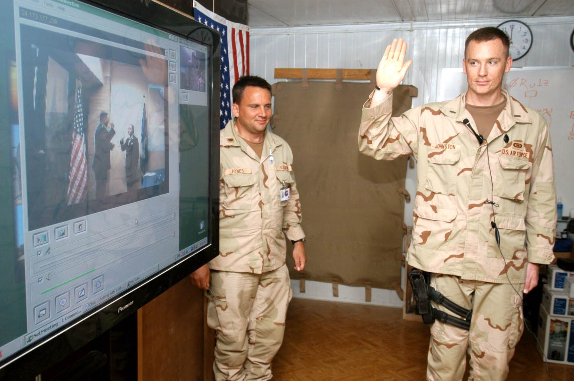 BALAD AIR BASE, Iraq -- Army Maj. Kenneth Hynes watches as 1st Lt. Eric Johnston repeats his oath given via video conference May 26 by Maj. Gary Barlet at Laughlin Air Force Base, Texas.  Lieutenant Johnston, and his wife, 1st Lt. Sheila Johnston, were promoted together although they were separated by more than 7,000 miles.  He and Major Hynes are assigned to the Combined Joint Special Operations Task Force-Arabian Pennisula here.  Major Barlet is the 47th Communications Squadron commander at Laughlin, where the lieutenant is deployed from.  (U.S. Army photo by Sgt. Ryan Creel)