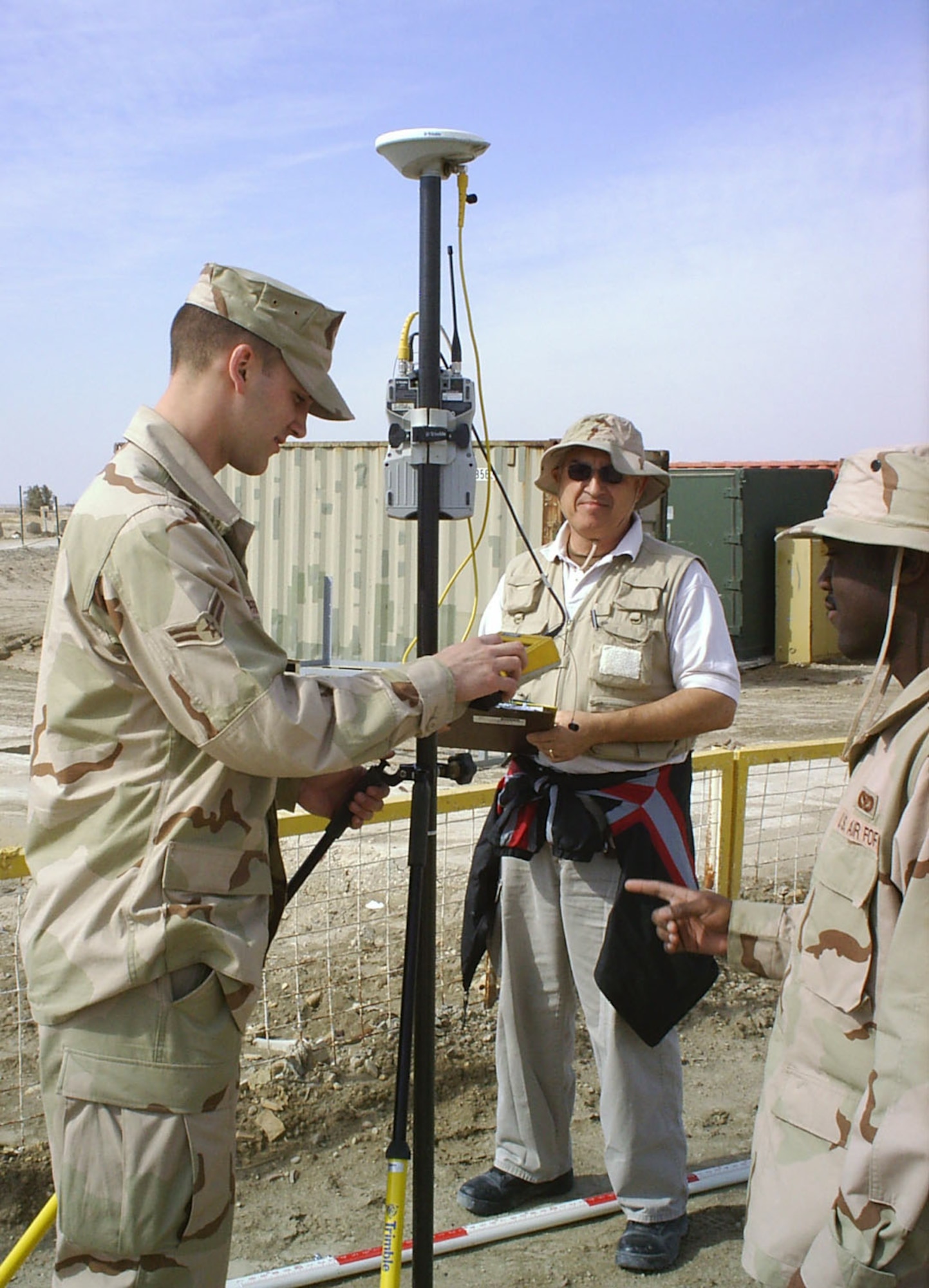 TALLIL AIR BASE, Iraq -- (From Left) Airman 1st Class Mitchell Zipprich, Jan Noppen and Senior Airman Larry Washington monitor a unit used to gather information from a Global Positioning System satellite.  The Airmen are part of a joint crew of Air Force and Army civil engineers who travel outside the perimeter to improve conditions for Soldiers and Iraqis.  They are assigned to the 732nd Expeditionary Civil Engineering Squadron's Detachment 2, and Mr. Noppen is a contractor.  (U.S. Air Force photo by Maj. Thomas Niichel)