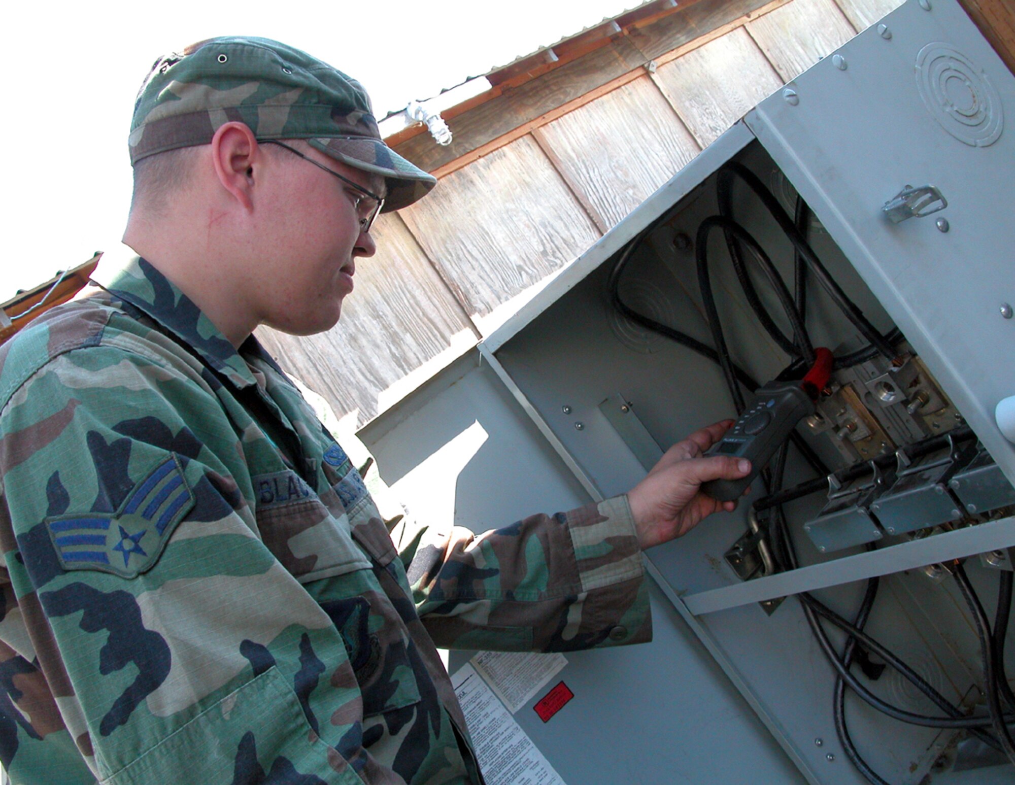 CAMP WY-WUH, Alaska -- Senior Airman Christopher Blackburn tests amperage of an electrical power isolation switch that serves the camp.  He is deployed here supporting Operation Alaskan Road from the 36th Civil Engineer Squadron at Andersen Air Force Base, Guam.  (U.S. Air Force photo by Maj. Richard Sater)