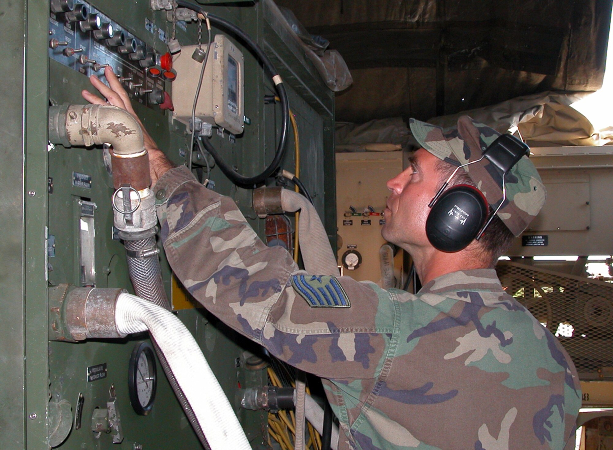 CAMP WY-WUH, Alaska -- Tech. Sgt. Brian Geske checks pressure gauges and production flow on a reverse osmosis water purification unit.  The unit purifies the water from a local stream and then pumps it into storage bladders for camp use.  Sergeant Geske is deployed here supporting Operation Alaskan Road from the Kansas Air National Guard's 190th Civil Engineer Squadron.  (U.S. Air Force photo by Maj. Richard Sater)