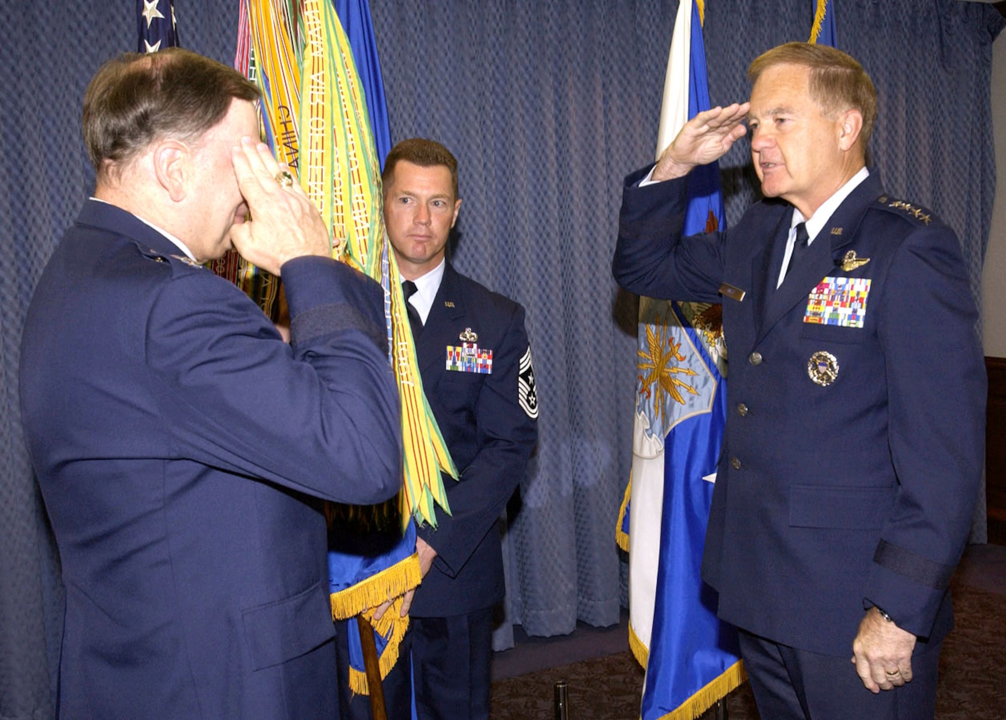 WASHINGTON -- Gen. Ronald E. Keys (right) salutes Air Force Chief of Staff Gen. John P. Jumper as Chief Master Sgt. David Popp holds the guideon during an assumption of command ceremony here May 27.  General Keys assumed command of Air Combat Command.  Chief Popp is ACC's command chief master sergeant.  (U.S. Air Force photo by Master Sgt. Jim Varhegyi)

