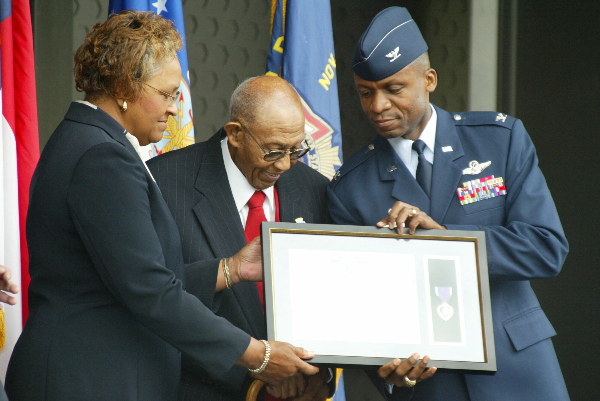 MOUNT AIRY, N.C. -- Col. Darren McDew (right), 43rd Airlift Wing commander, shows Gloria Scott and Buster Jones the Air Force citation honoring Captain James R. Jones with a Purple Heart Oct. 22 at Blackmon Amphitheater in Mount Airy, N.C. (U.S. Air Force photo by Senior Airman Stacia Zachary)