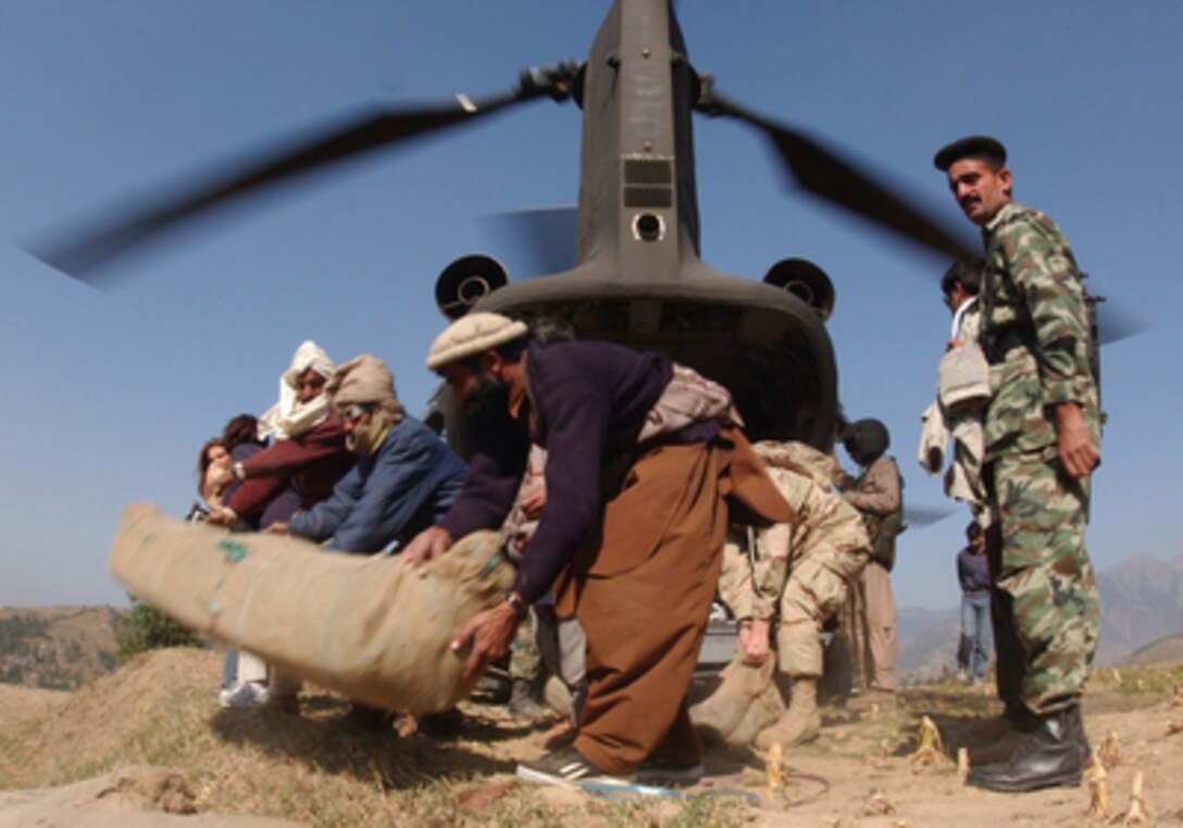 Pakistani workers unload tents, canned goods, water and other humanitarian relief supplies from a U.S. Army CH-47D Chinook helicopter in Bagru, Pakistan, on Oct. 31. 2005. The Department of Defense is supporting the State Department by providing disaster relief supplies and services following the massive earthquake that struck Pakistan and parts of India and Afghanistan. 