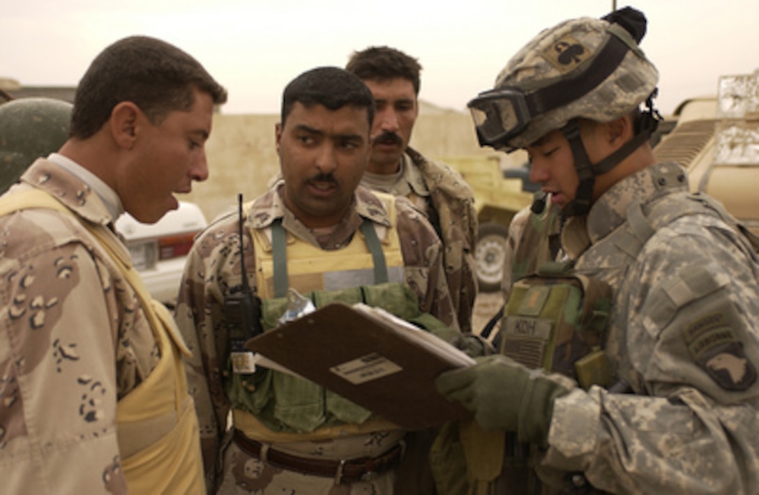 U.S. Army 2nd Lt. Tom Koh (right) briefs Iraqi Army soldiers about an upcoming mission to conduct a joint foot patrol with U.S. soldiers in the village of Namla, Iraq, on Oct. 31, 2005. Koh is attached to 2nd Platoon, Alpha Company, 1st Battalion, 327th Infantry, 101st Airborne, Fort Campbell, Ky. 