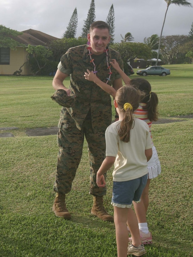Lance Cpl. Mark R. Drinkwater II, fire direction controlman, Alpha Battery, 1st Battalion, 12th Marine Regiment, smiles after receiving a lei from Ami Hyatt and his sister Julia Drinkwater. The girls were swept out by a current Sunday and Drinkwater, Staff Sgt. John Hyatt and Lance Cpl. Andrew Kopacek rescued them and Theresa Drinkwater, who also became a victim when she entered the water in an effort to rescue the girls.