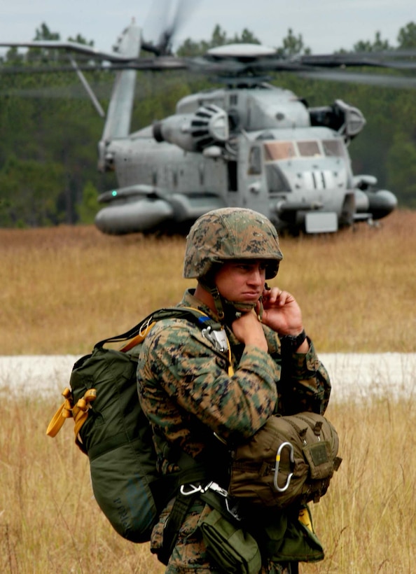 Staff Sgt. Timothy McCoy and Sgt. Abel Villarreal work on an AH-1 Cobra helicopter to remove the helicopters infrared guidance system, as Sgt. Chris Mergen pushes from the cockpit.  The system is key to the Cobra?s ability to accurately hit targets, and the maintenance Marines from the Camp Al Qaim detachment of Marine Light Attack Helicopter Squadron 369 replaced the large part in a few hours.