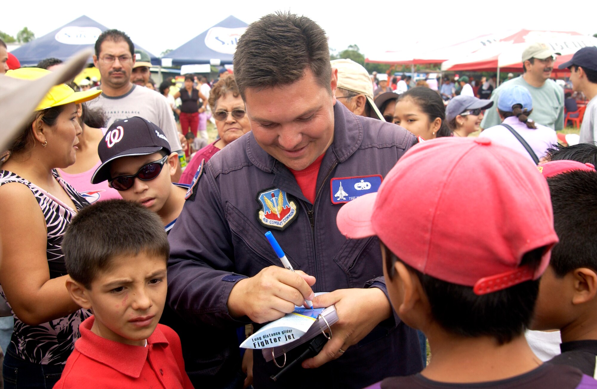 ILOPANGO AIR BASE, El Salvador (AFPN) --Tech. Sgt. Michael Camp, a member of the Air Combat Command's F-15 West Coast Demontration Team from Eglin Air Force Base, Fla., signs autographs during the Ilopango Air Show 2005 in El Salvador Oct. 30. Sergeant Camp is the team's avionics expert. (U.S. Air Force photo by Staff Sgt. Matthew Lohr) 