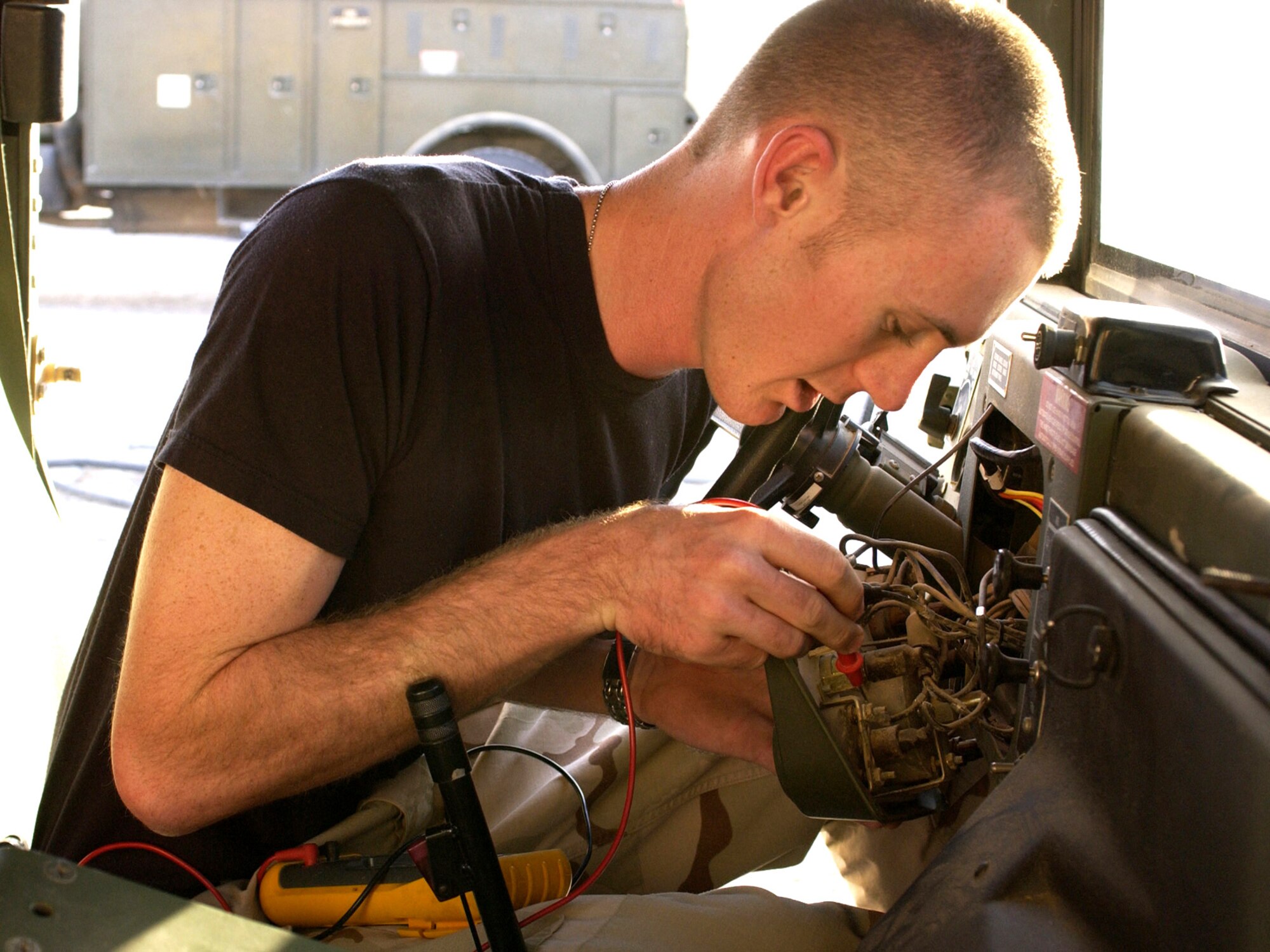 SOUTHWEST ASIA (AFPN) -- Airman 1st Class Erik Elder installs a vehicle radio system in an armored HUMVEE for the 386th Expeditionary Explosive Ordinance Detachment here.  Airman Elder is a ground radio maintenance technician deployed from the 35th Communications Squadron at Misawa Air Base, Japan. (U.S. Air Force photo by Senior Airman Michael Garza) 