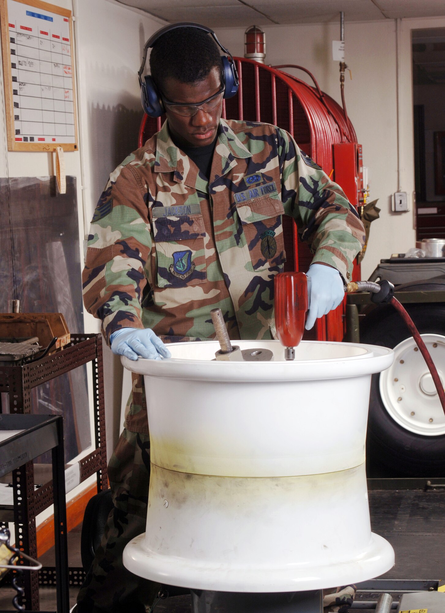 YOKOTA AIR BASE, Japan (AFPN) -- Senior Airman William Jackson uses an impact wrench to remove bolts from a C-130 Hercules main landing gear wheel. He is an aero repair technician with the 374th Maintenance Squadron.  (U.S. Air Force photo by Master Sgt. Val Gempis) 