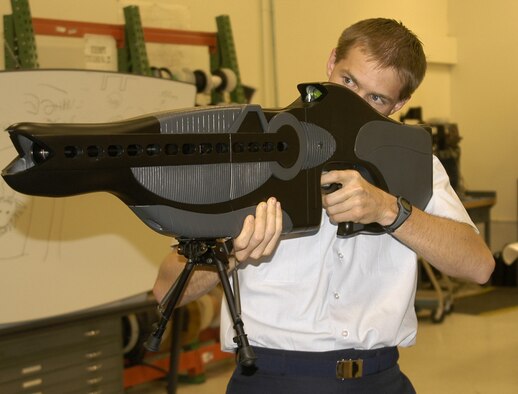 KIRTLAND AIR FORCE BASE, N.M. (AFPN) -- Capt. Drew Goettler demonstrates the Personnel Halting and Stimulation Response, or PHaSR, a non-lethal illumination technology developed by the laboratory's ScorpWorks team. The technology is the first man-portable, non-lethal deterrent weapon intended for protecting troops and controlling hostile crowds. The laser light used in the weapon temporarily impairs aggressors by illuminating or "dazzling" individuals, removing their ability to see the laser source. (U.S. Air Force photo)