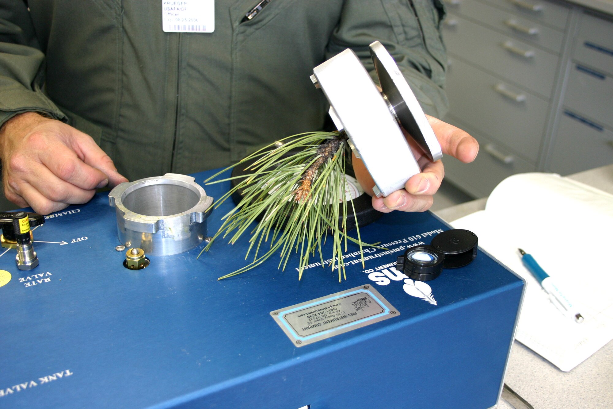 U.S. AIR FORCE ACADEMY, Colo. (AFPN) -- Maj. Jerry Krueger uses the plant pressure chamber to asses the hydration level of pine needles. The research is part of the field ecology class here. (U.S. Air Force photo) 