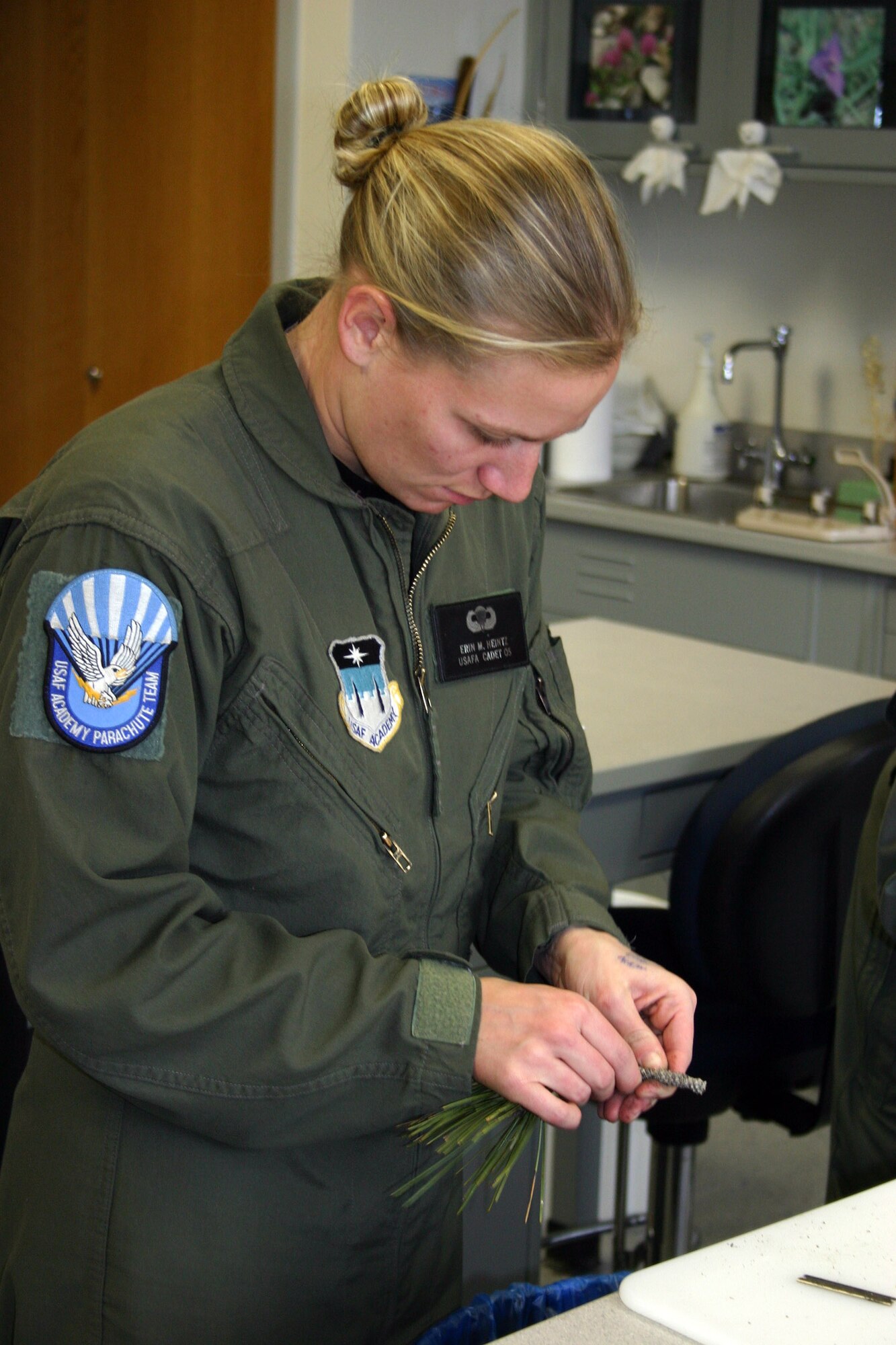 U.S. AIR FORCE ACADEMY, Colo. (AFPN) -- Cadet Erin Heintz works with pine needles in the biology department here. The Air Force Academy Biology Department is working to determine a correlation between the infrared signature and the water potential of the ponderosa pine needle. They can then fly an Unmanned Aerial Vehicle over the local pine trees with a sensor that can detect which trees have been infected by measuring the amount of moisture in the pine needles. (U.S. Air Force photo) 