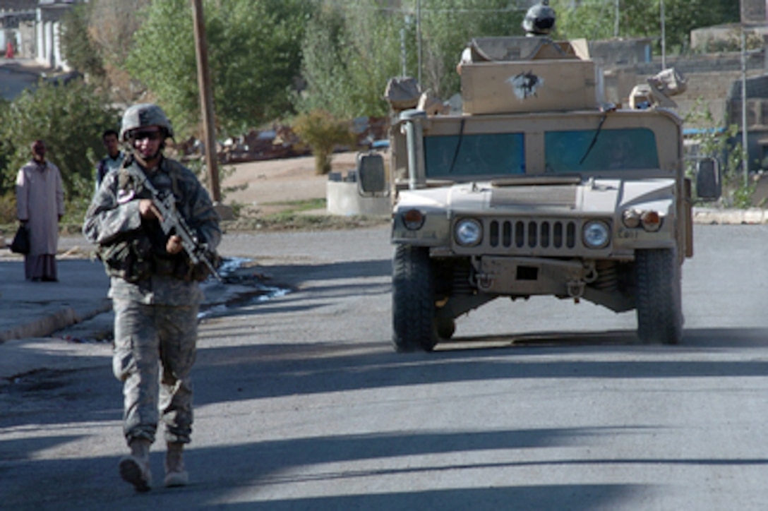 Soldiers from the Army's 2nd Battalion, 325th Airborne Infantry Regiment, 82nd Airborne Division, conduct a routine security patrol on foot and in a Humvee in Tal Afar, Iraq, on Nov. 1, 2005. The soldiers and members of the Iraqi Army security forces are providing security for the region of Tal Afar in order to disrupt insurgent safe havens and to clear weapons cache sights. 