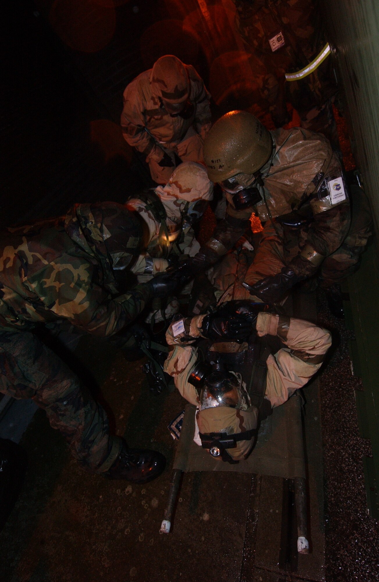 Members of the 352nd Special Operations Group perform self-aid and buddy care suited in full chemical warfare gear. The Ability to Survive and Operate is a major graded portion of the inspection. 