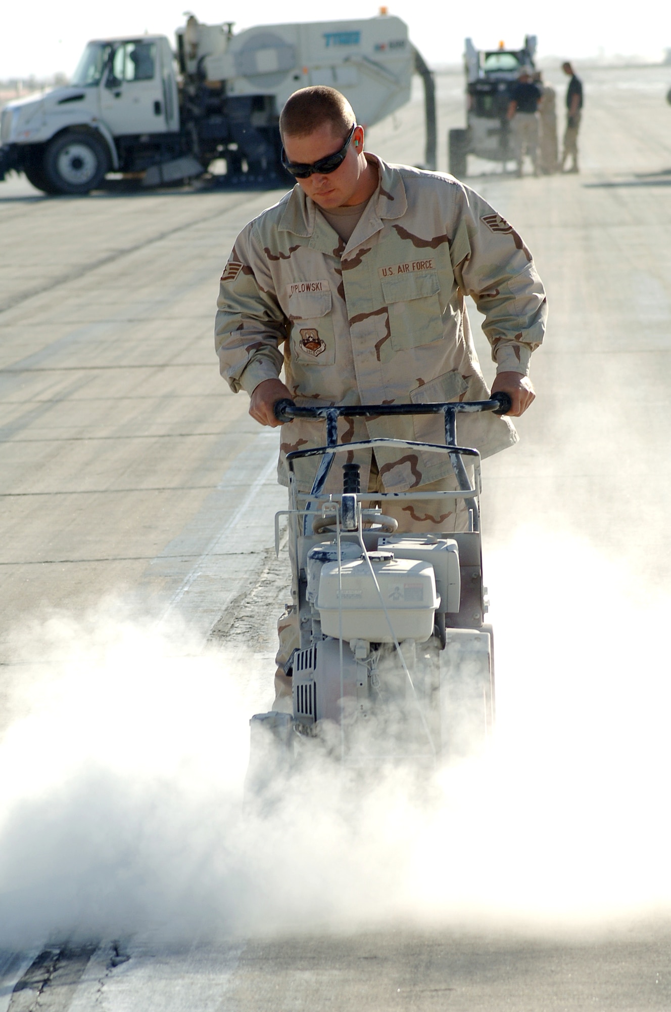 BAGRAM AIR BASE, Afghanistan (AFPN) -- Staff Sgt. Tony Dyplowski uses a concrete saw to repair the runway here. In the last two months, a nine-person spall repair team has made more than 200 repairs to sustain more than 3,000 operations each week in support of Operation Enduring Freedom. Sergeant Dyplowski, a 455th Expeditionary Civil Engineer Squadron pavements and equipment craftsman, deployed from Davis-Monthan Air Force Base, Ariz. (U.S. Air Force photo by Capt. James H. Cunningham)
