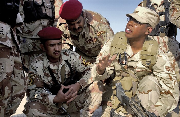 AD DIWANIYAH, Iraq -- Iraqi Soldiers listen intently as Senior Airman Patrick Dixon instructs on loading procedures of an M-249 Squad Assault Weapon.  Airman Dixon is deployed from the 1st Combat Camera Squadron at Charleston Air Force Base, S.C. (U.S. Air Force photo by Capt. Mark Harper) 