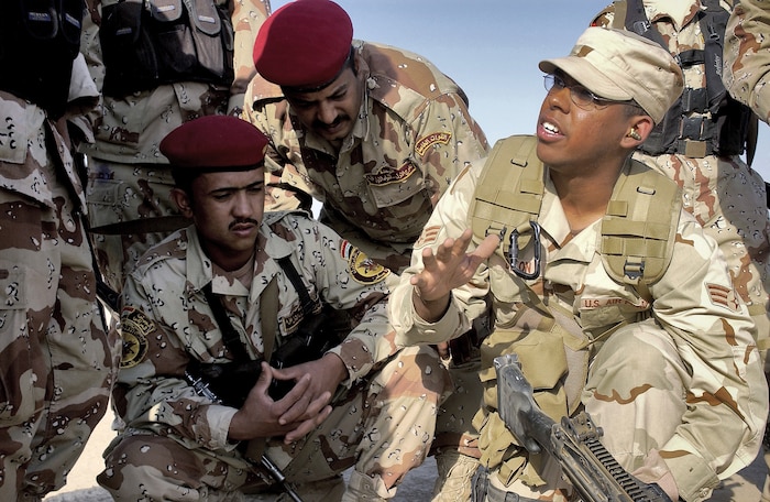 AD DIWANIYAH, Iraq -- Iraqi Soldiers listen intently as Senior Airman Patrick Dixon instructs on loading procedures of an M-249 Squad Assault Weapon.  Airman Dixon is deployed from the 1st Combat Camera Squadron at Charleston Air Force Base, S.C. (U.S. Air Force photo by Capt. Mark Harper) 